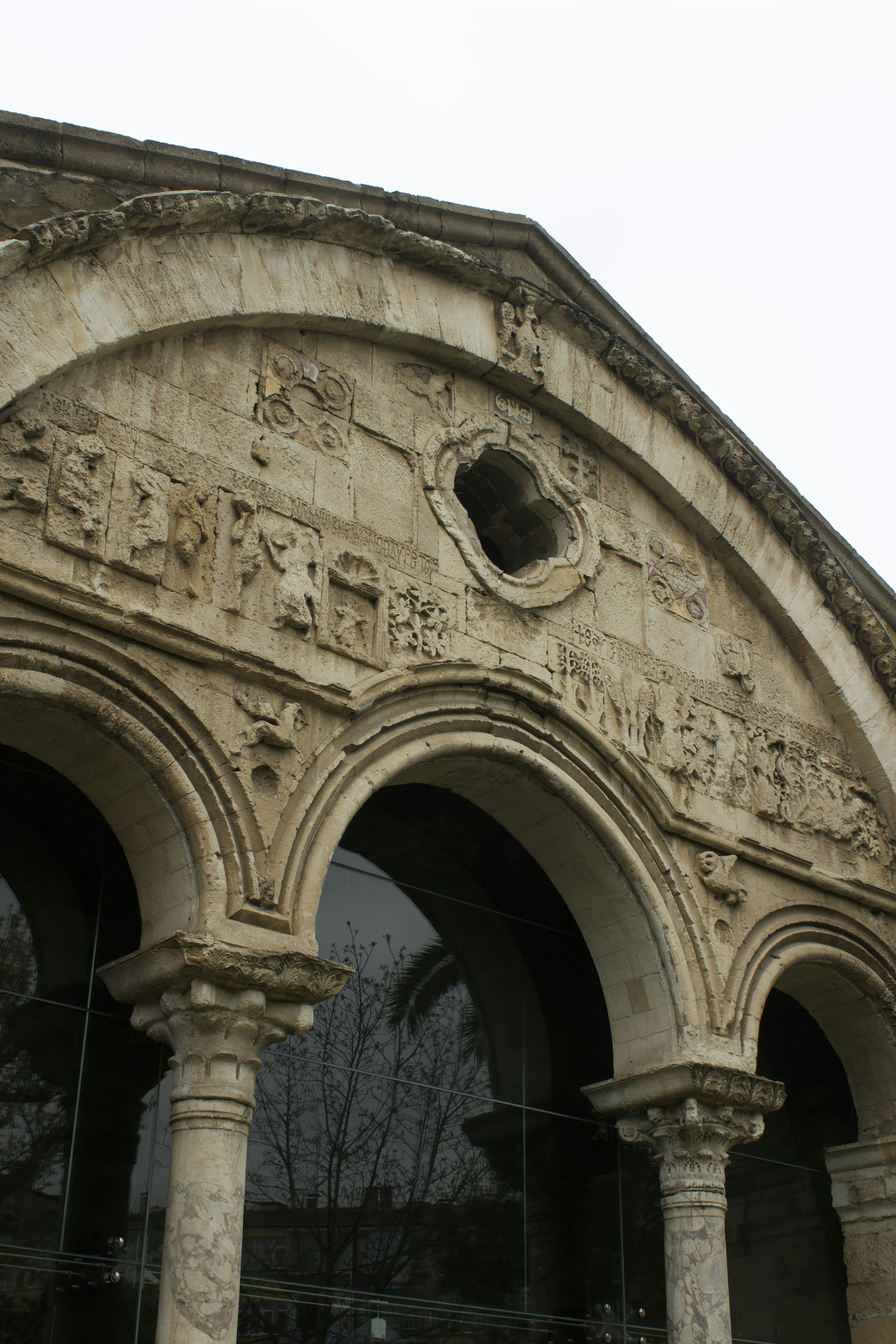 Detailed carvings adorn an ancient arched building facade.