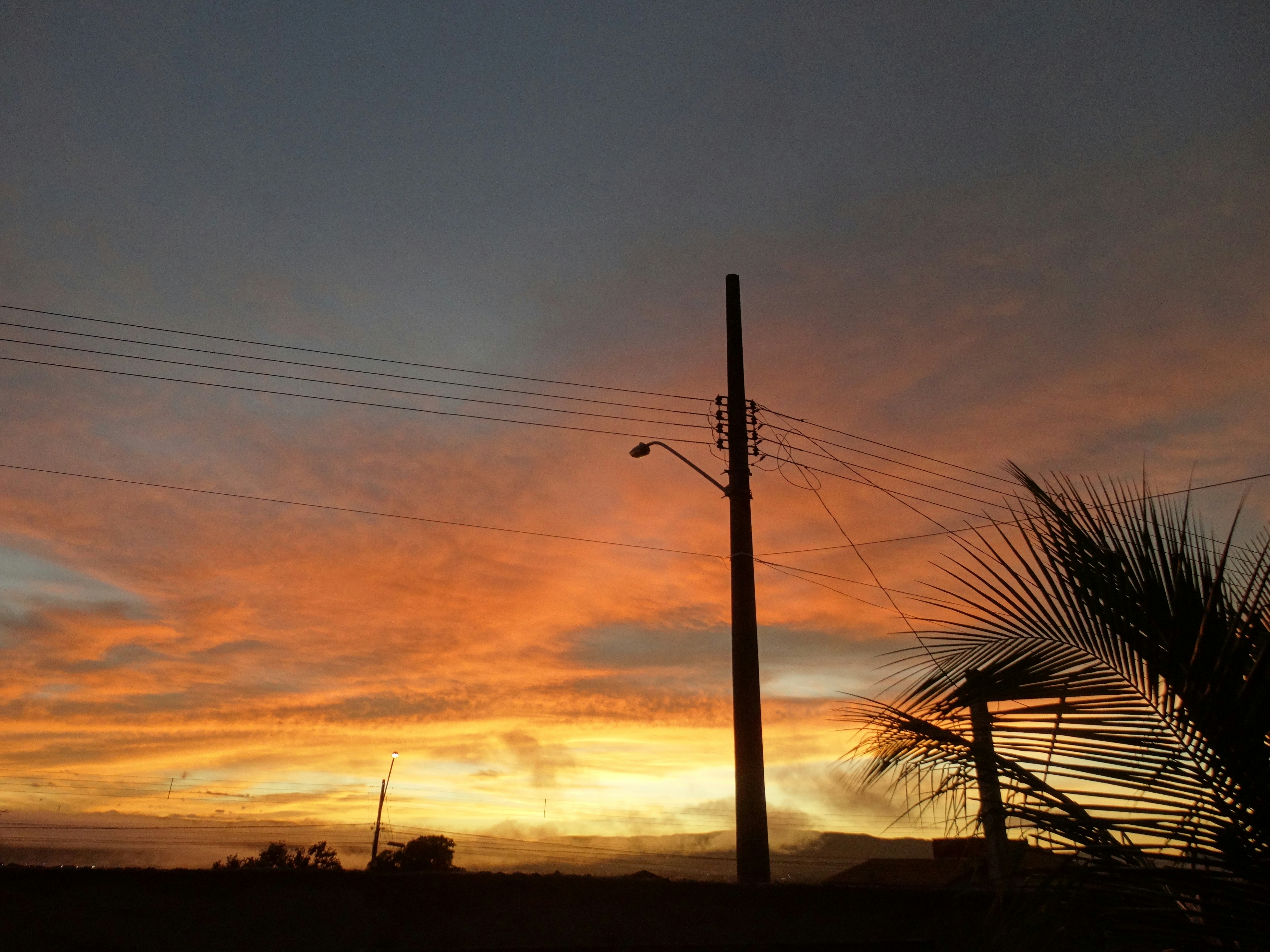 Vibrant sunset with telephone poles in silhouette.