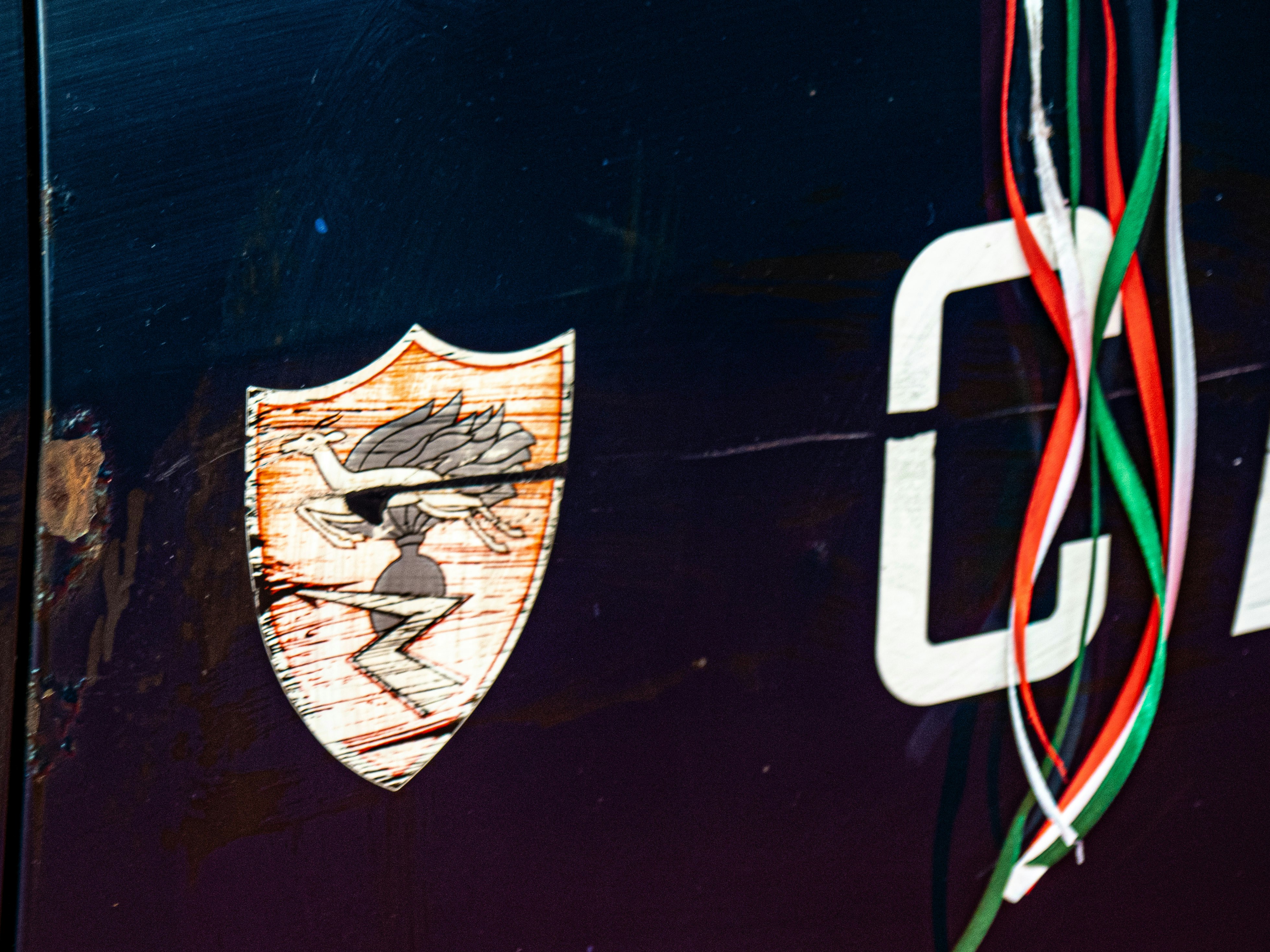 Logo and ribbons are displayed on a dark surface