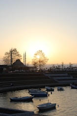 Boats are in a bay at sunset.