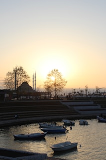 Boats are in a bay at sunset.