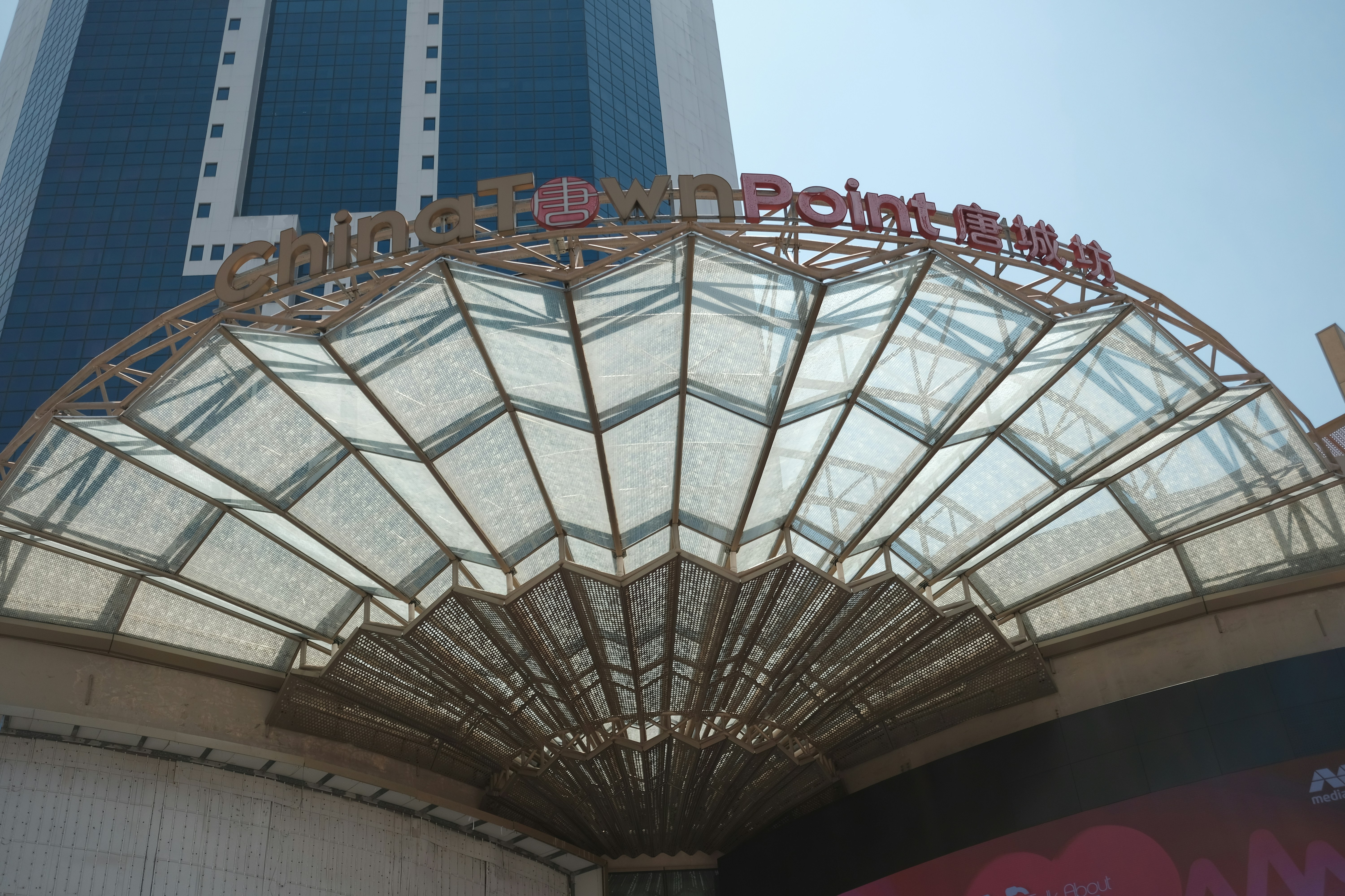 A mall entrance with a glass canopy.