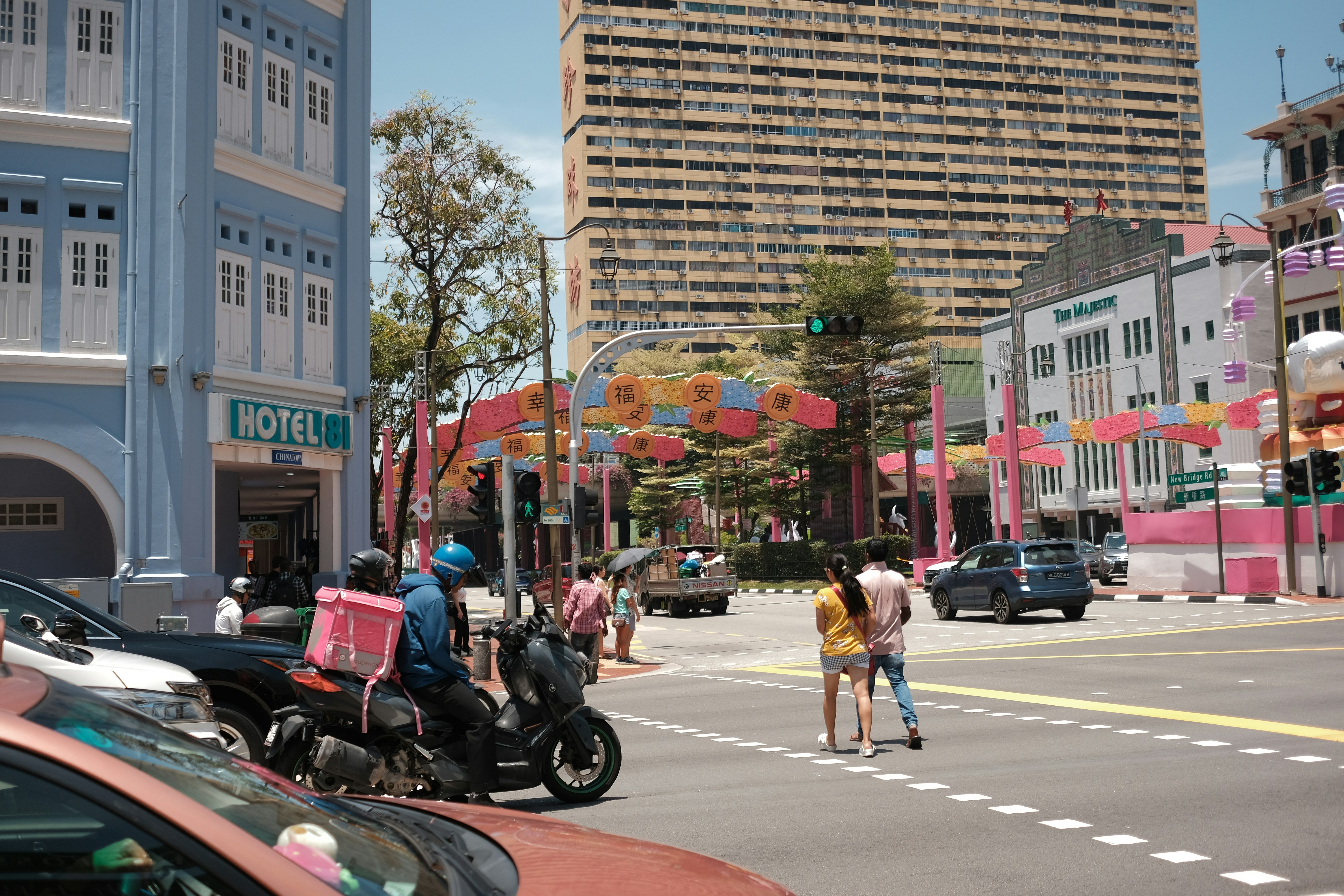 A street scene with buildings, cars, and people.