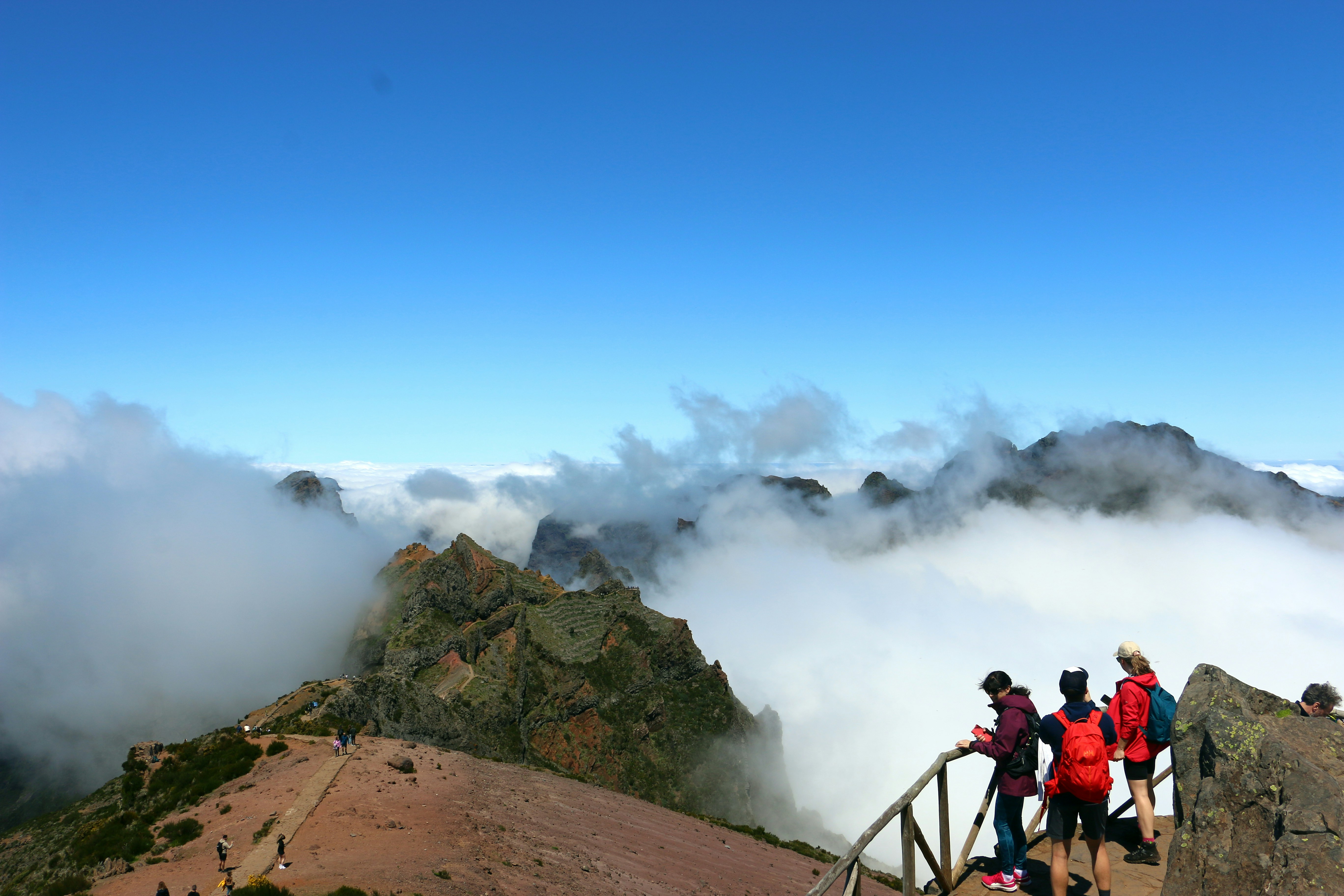 Hikers enjoy mountain views above the clouds.
