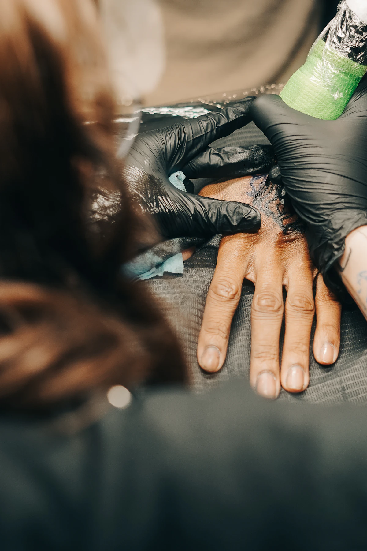 Tattoo artist working with black gloves