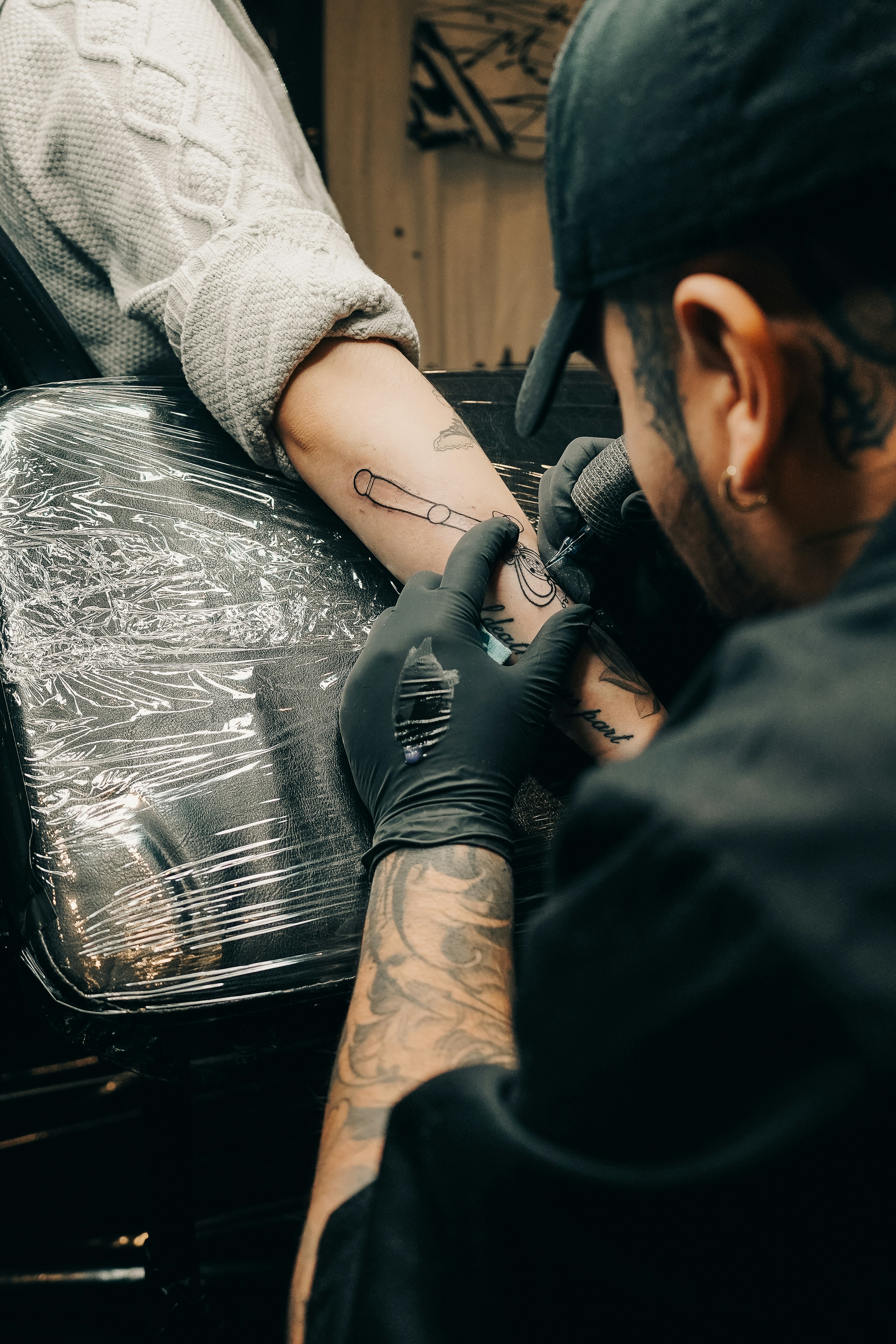 Un tatuador está entintando un diseño en un brazo.