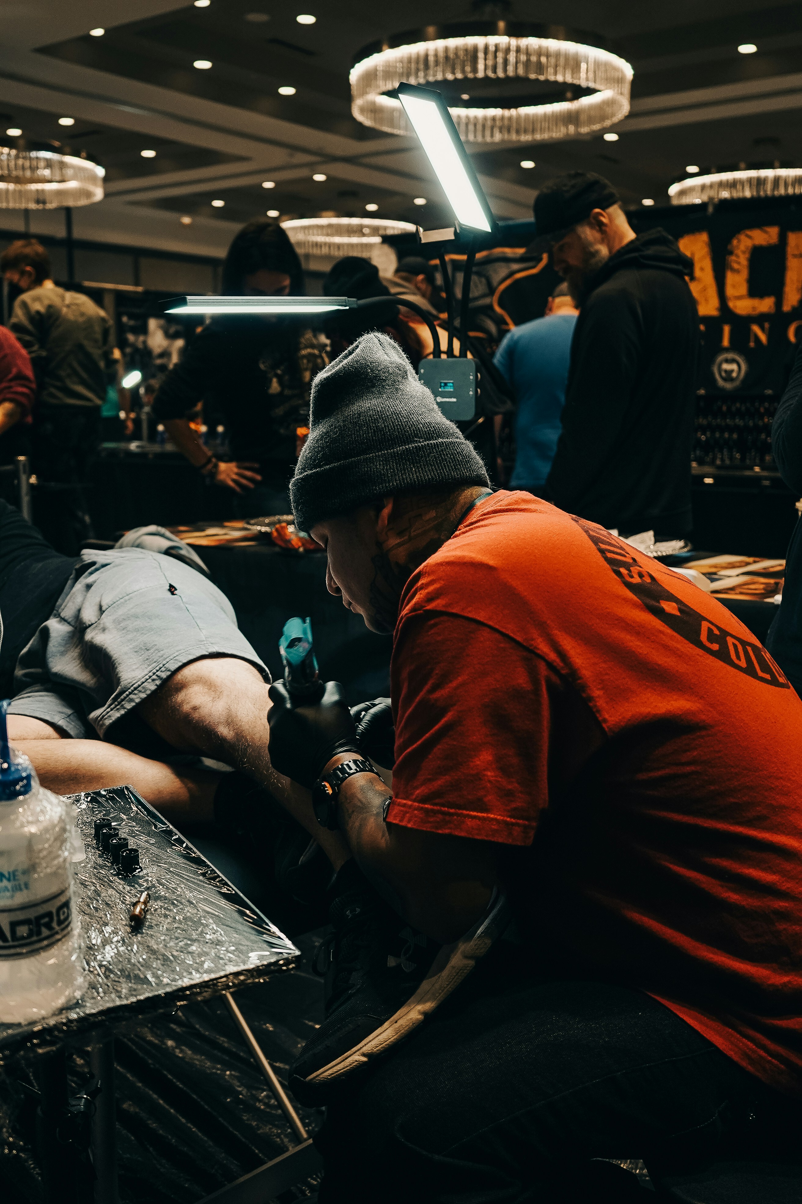 Un tatuador trabajando en un cliente.