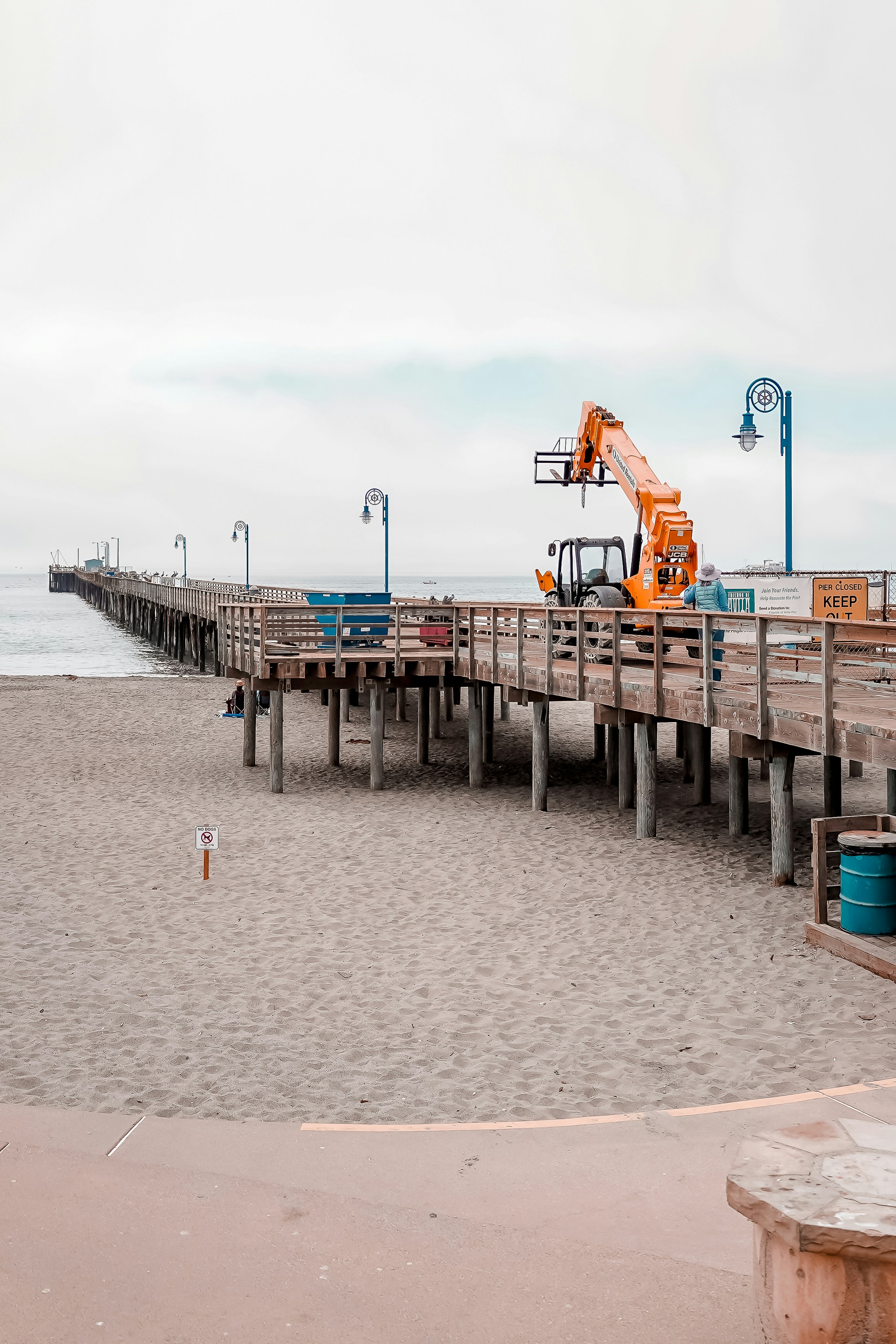 Una grúa naranja trabaja en un muelle.