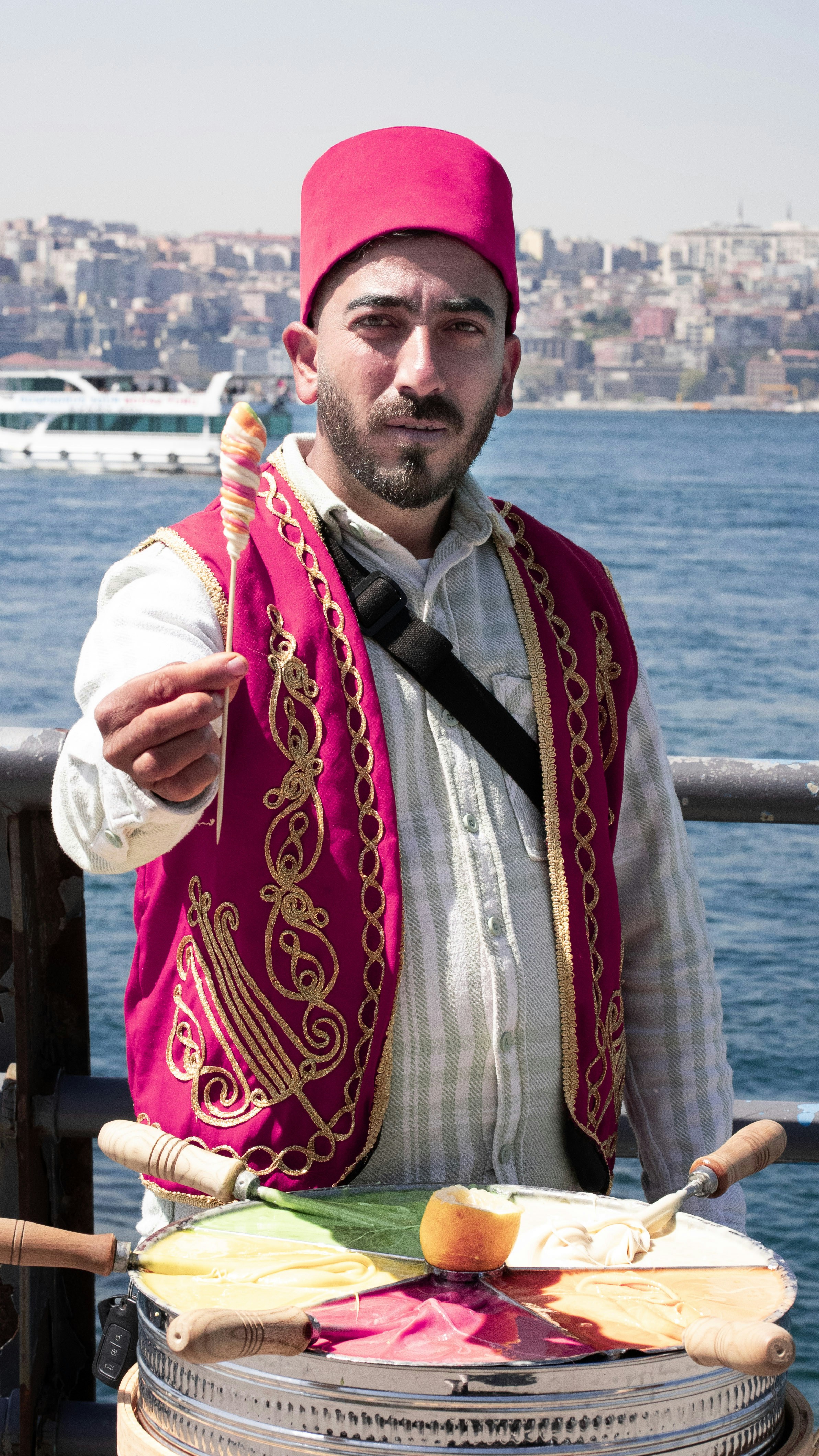 A man in traditional clothing offers candy.
