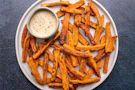 Sweet potato fries with a side of dipping sauce.