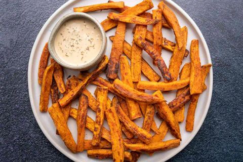 Sweet potato fries with a side of dipping sauce.