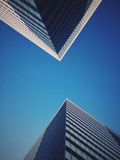Two skyscrapers meet at the blue sky.