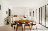 Modern dining room with table, chairs, and kitchen.