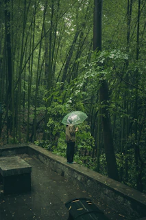 A person stands in the rain in a forest.