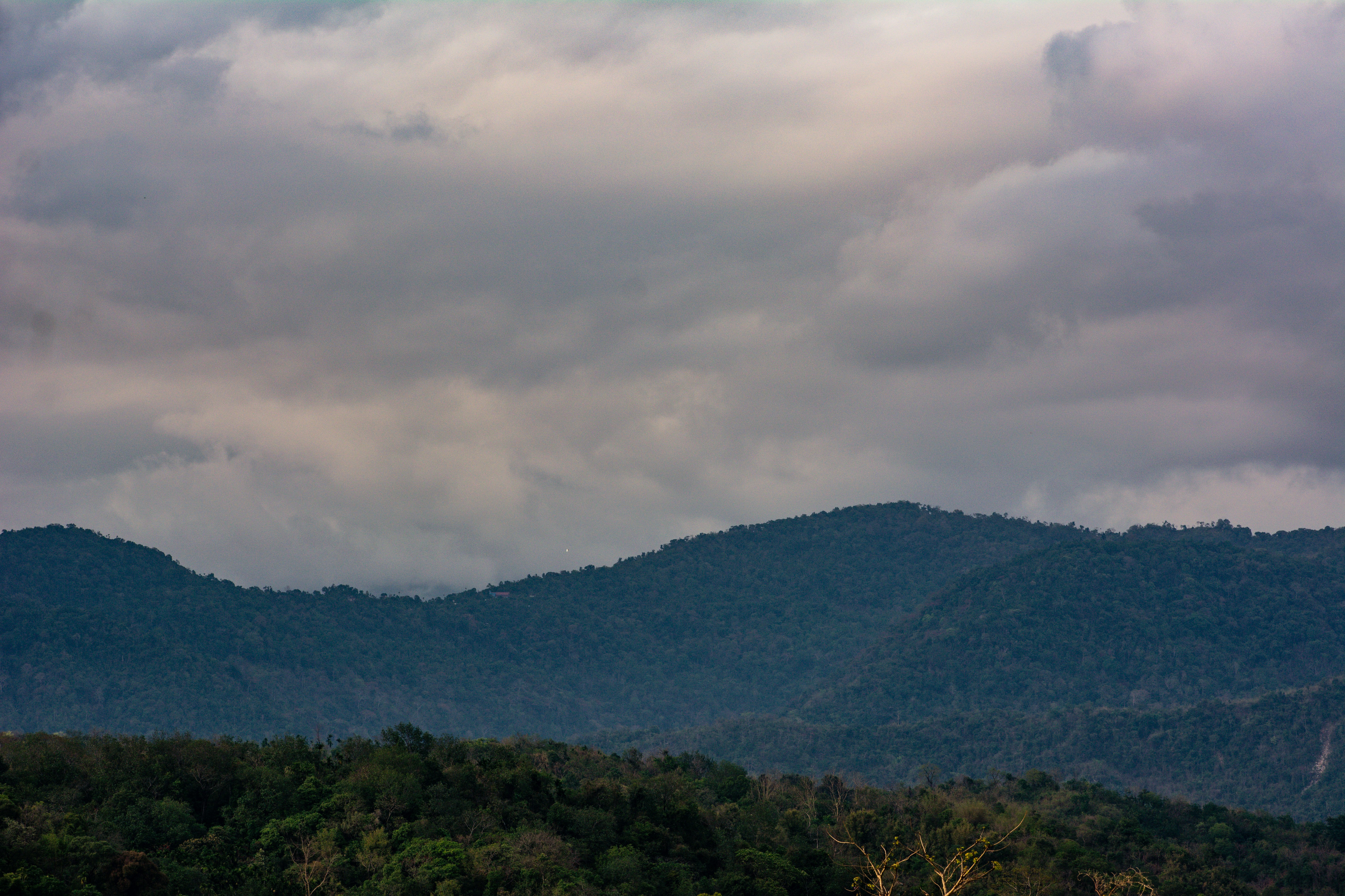 Mountains are under a cloudy sky.