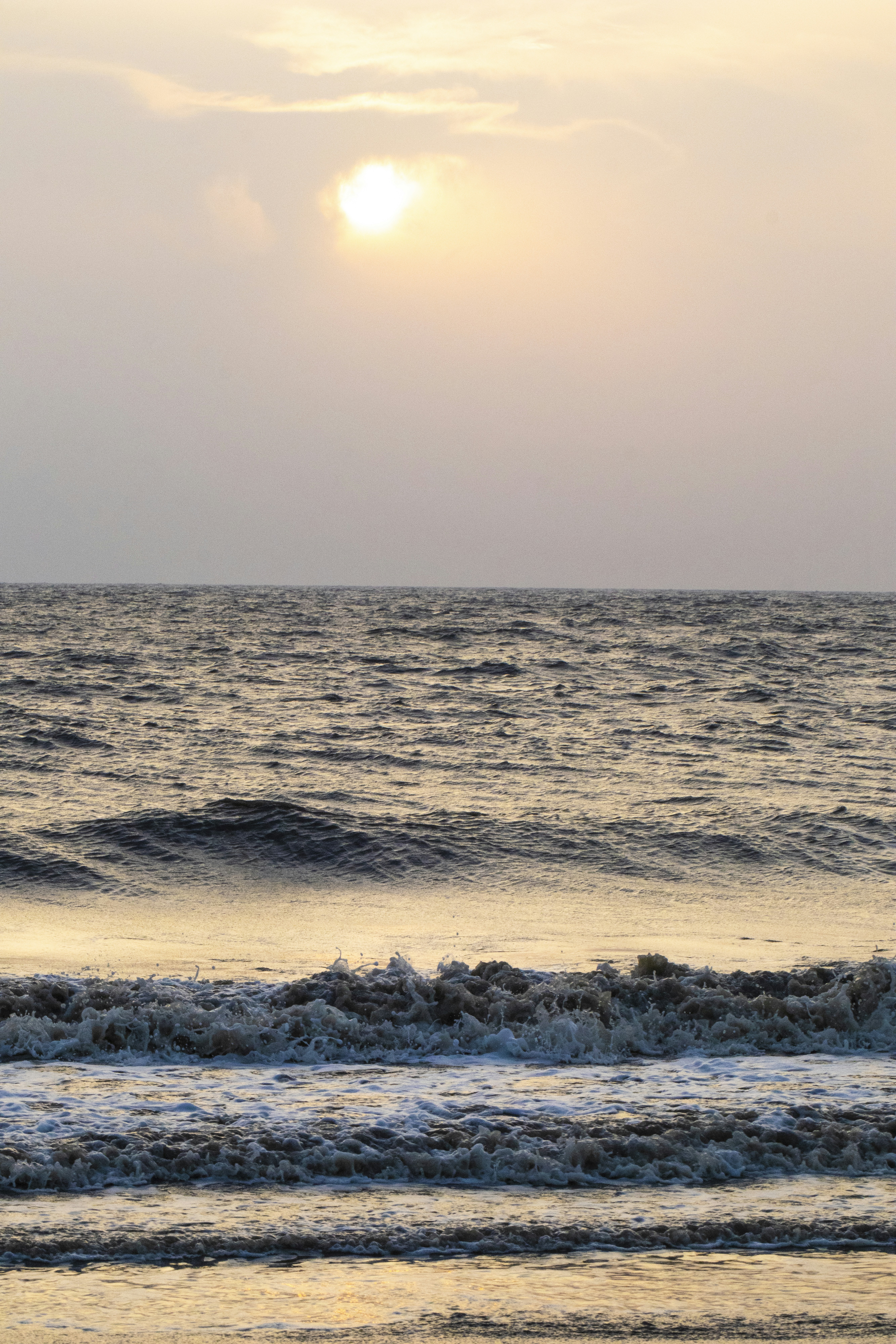 Sunrise over the wavy ocean.
