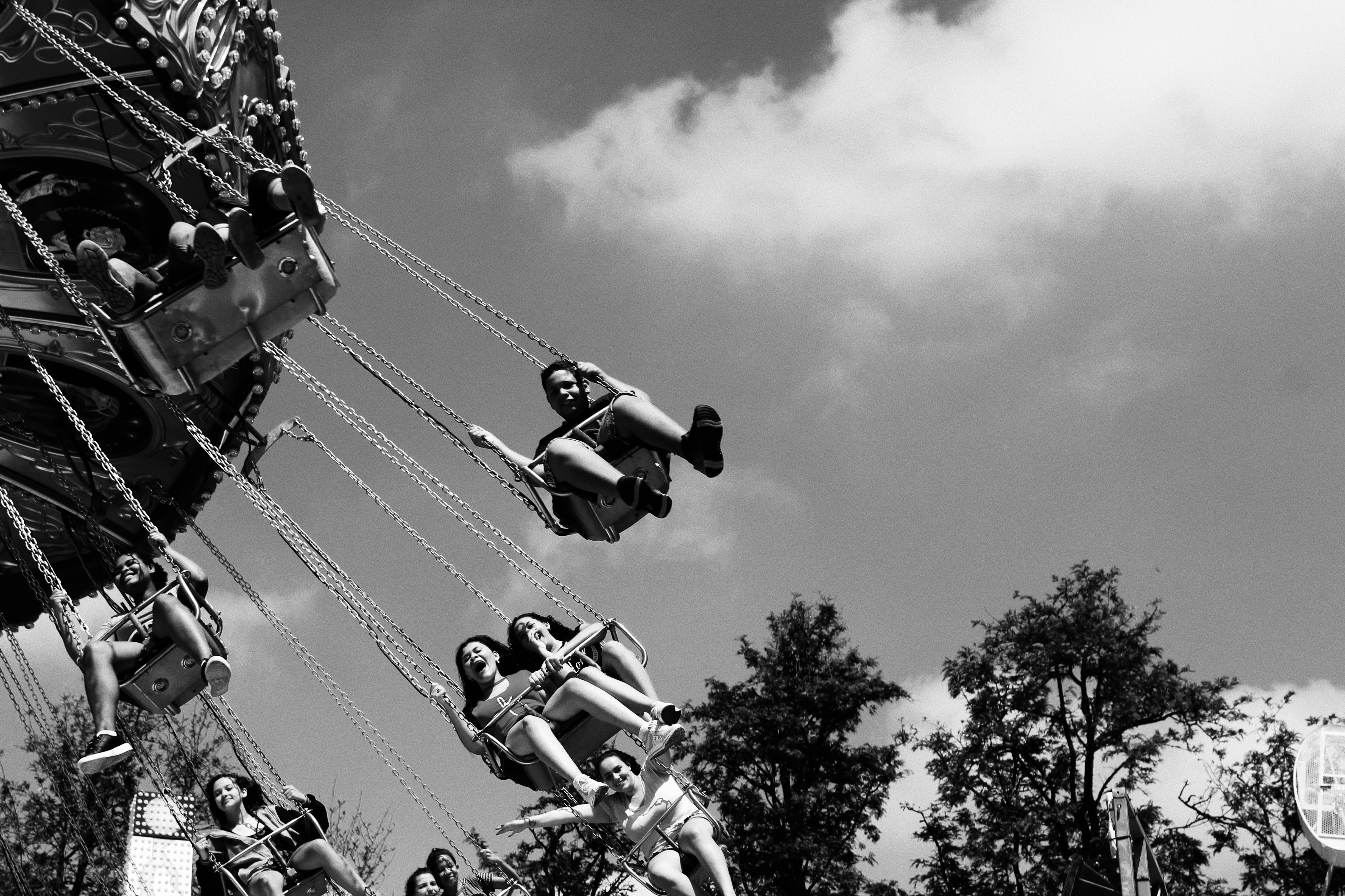 People enjoy a swing ride on a sunny day.