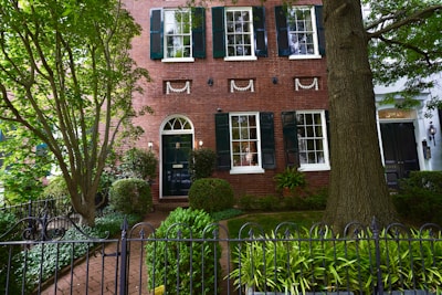 A charming, historic brick house with a green yard.