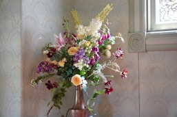A colorful bouquet in a copper vase.