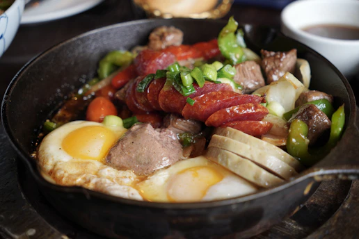 Breakfast skillet with sausage, eggs, and peppers.