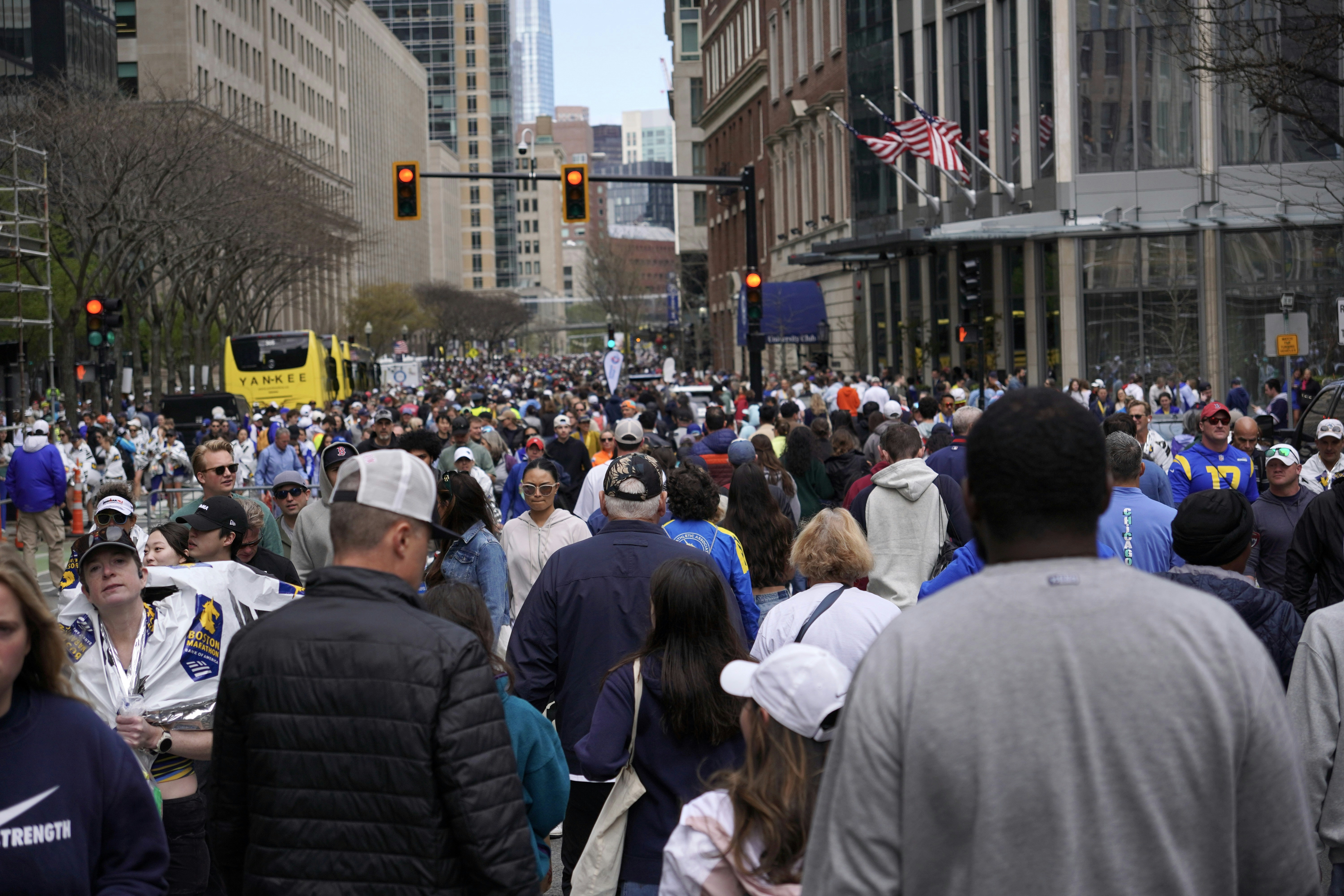 A large crowd of people is walking on a street.