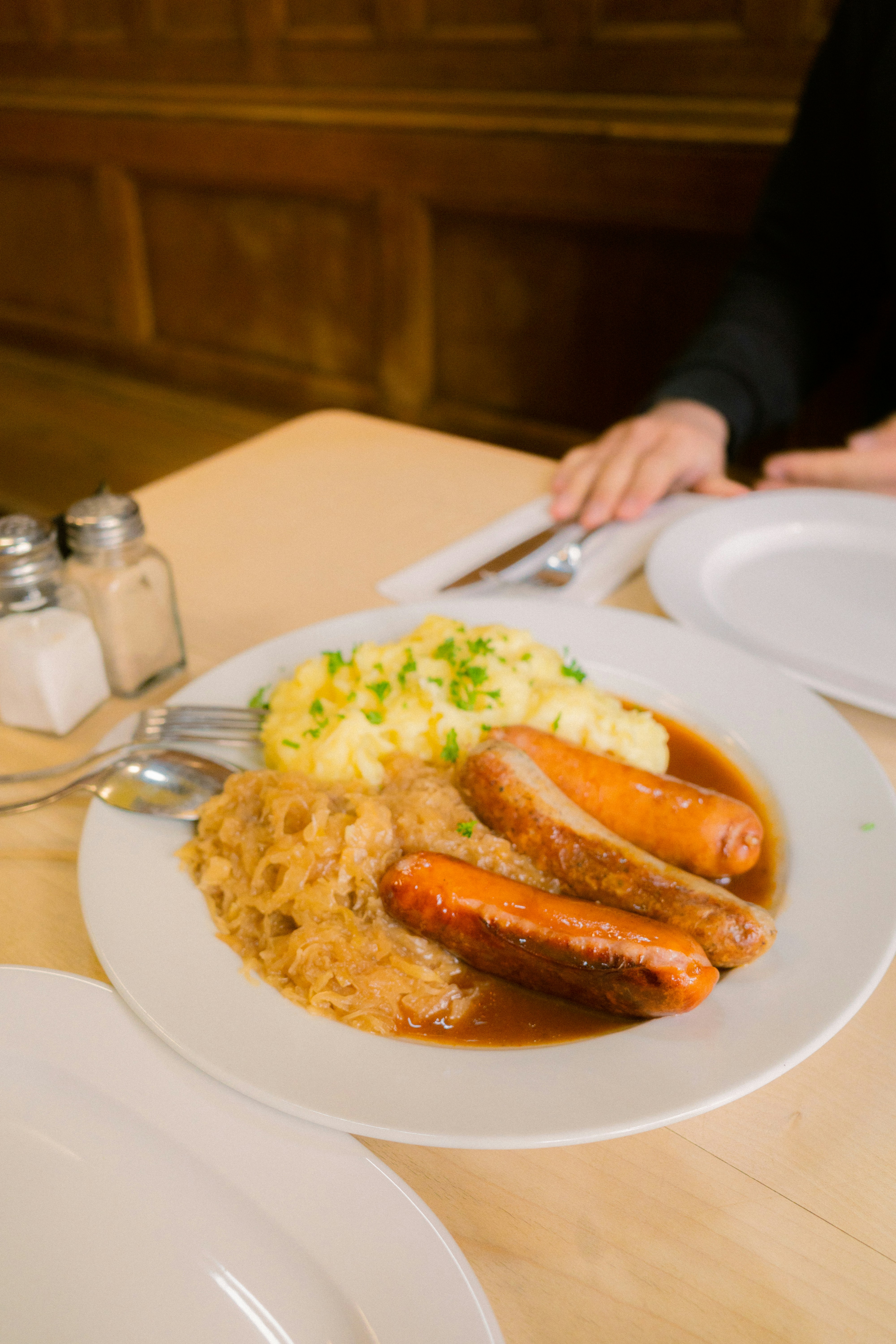 Sausages, sauerkraut, and mashed potatoes on a plate.