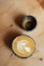 Espresso and latte art on a wooden surface.