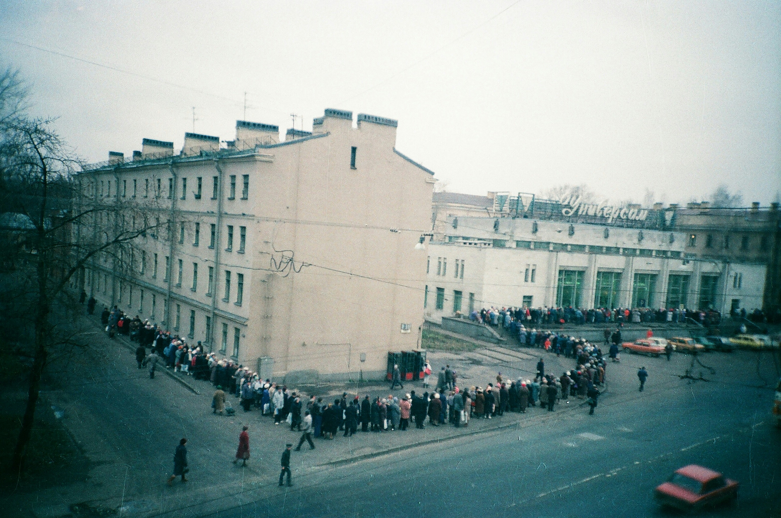 People are waiting in a long queue outside.
