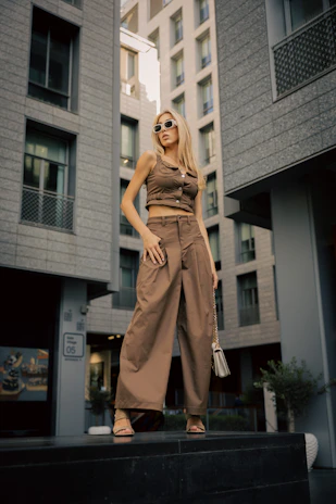 Woman poses fashionably in a modern urban setting.