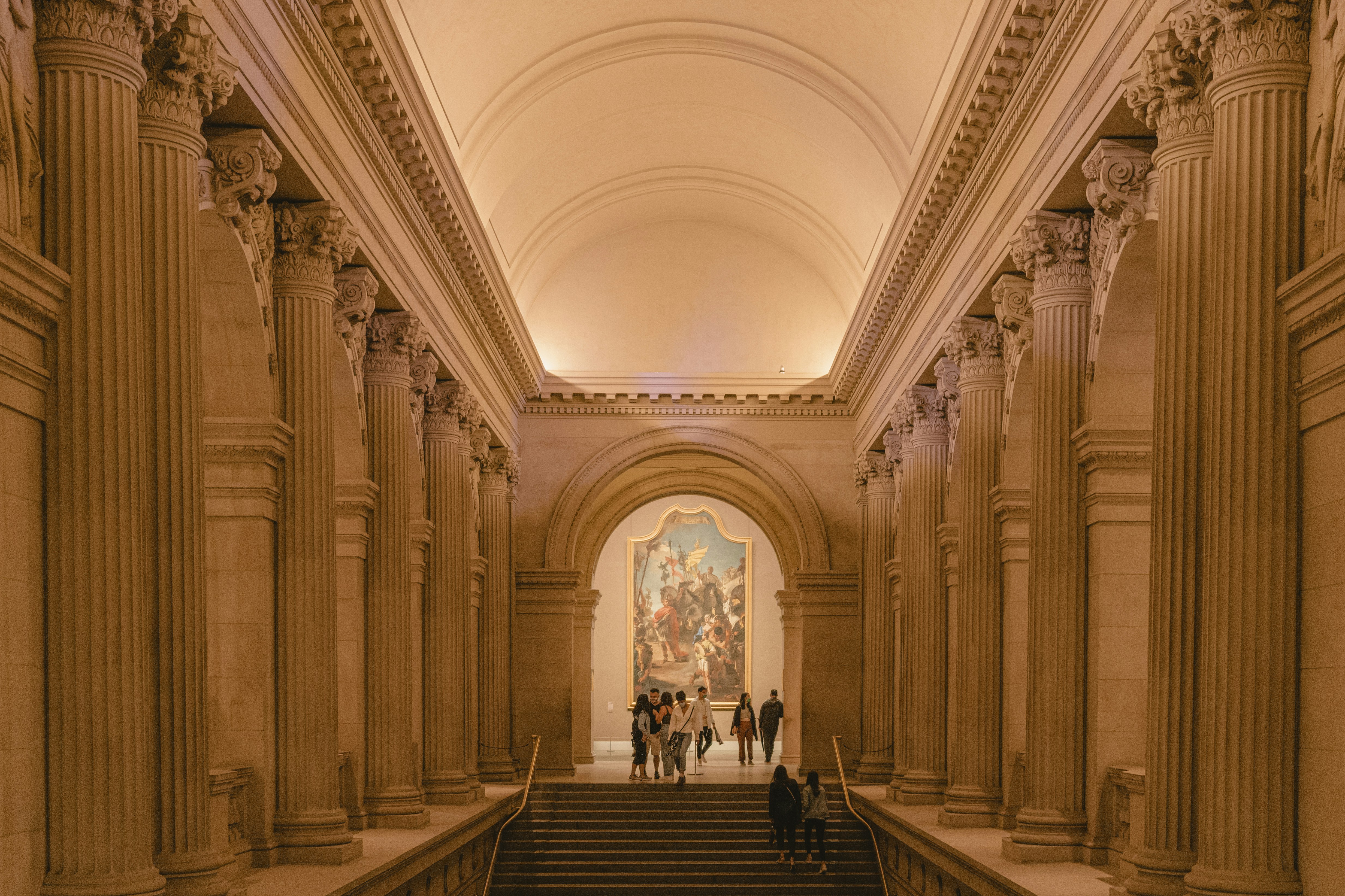 Elegant hallway with ornate pillars in a museum.