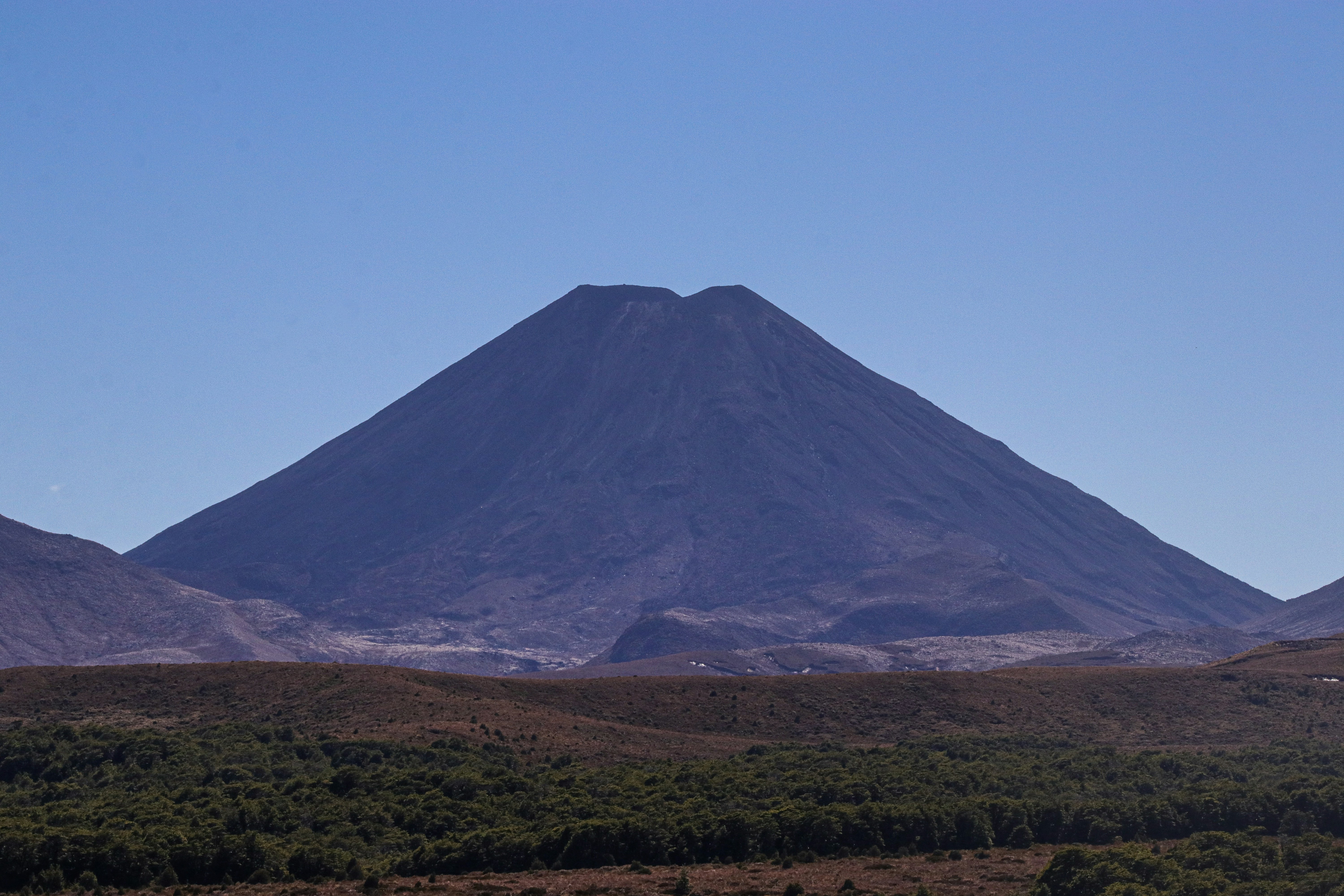 A majestic volcano stands proud under a clear sky.