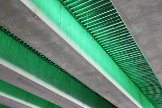 Green light illuminates a concrete underpass.