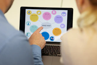 People are looking at a mind map on a laptop screen.