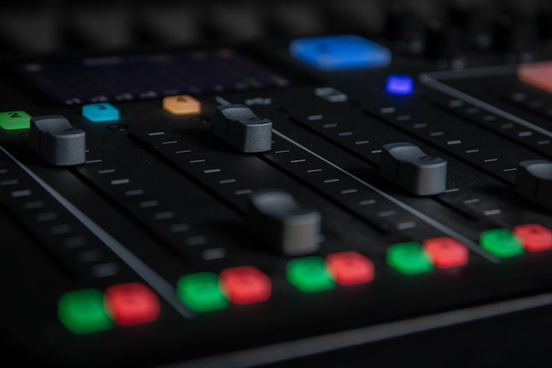 Detailansicht einer Audio-Konsole mit farbigen Fadern