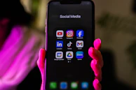 A smartphone displays social media app icons.