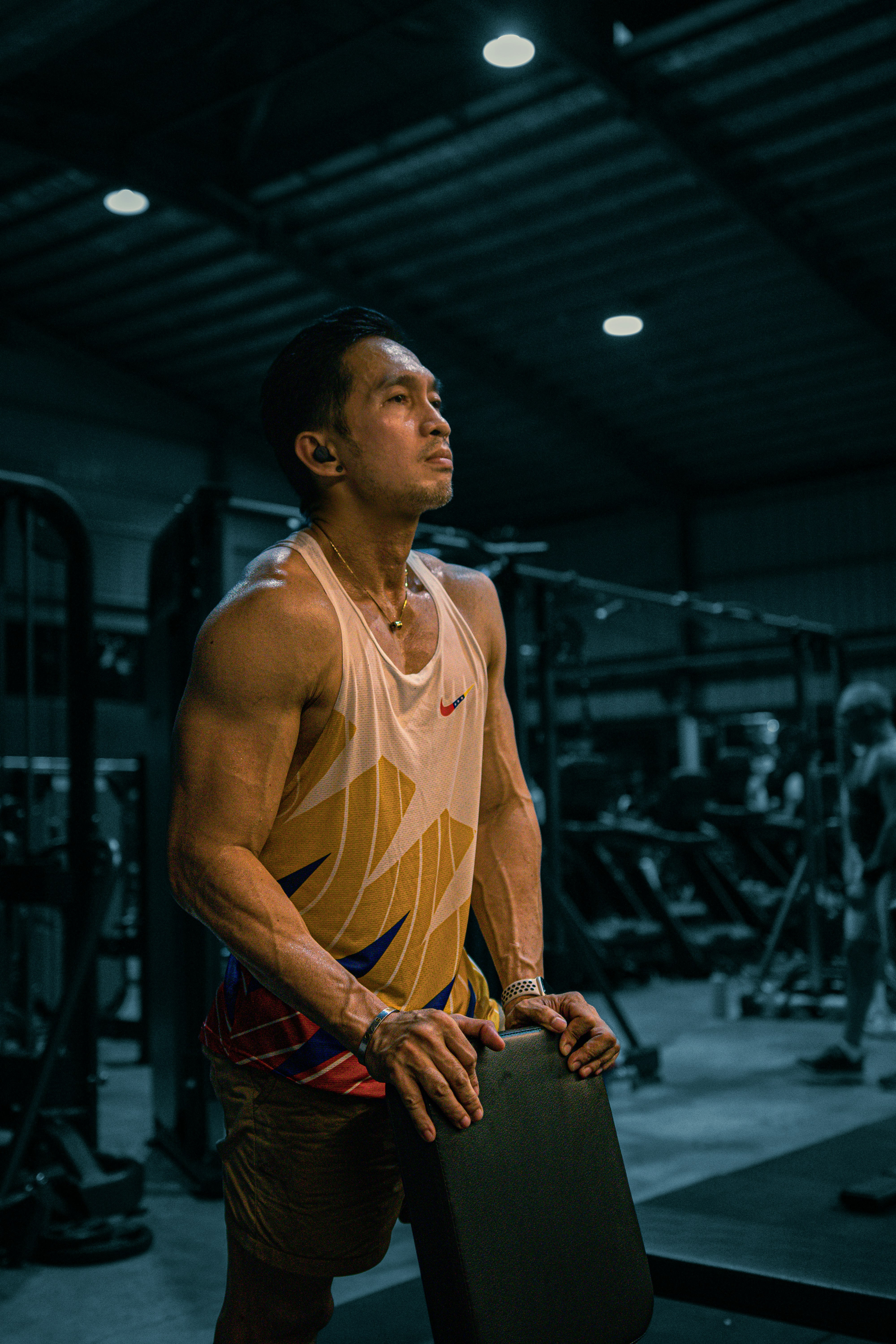 Muscular man in gym, looking upward.