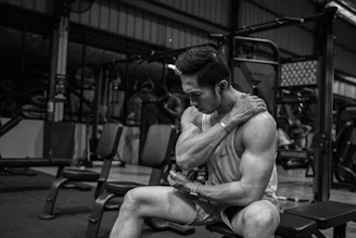 Man in gym massages his aching shoulder.