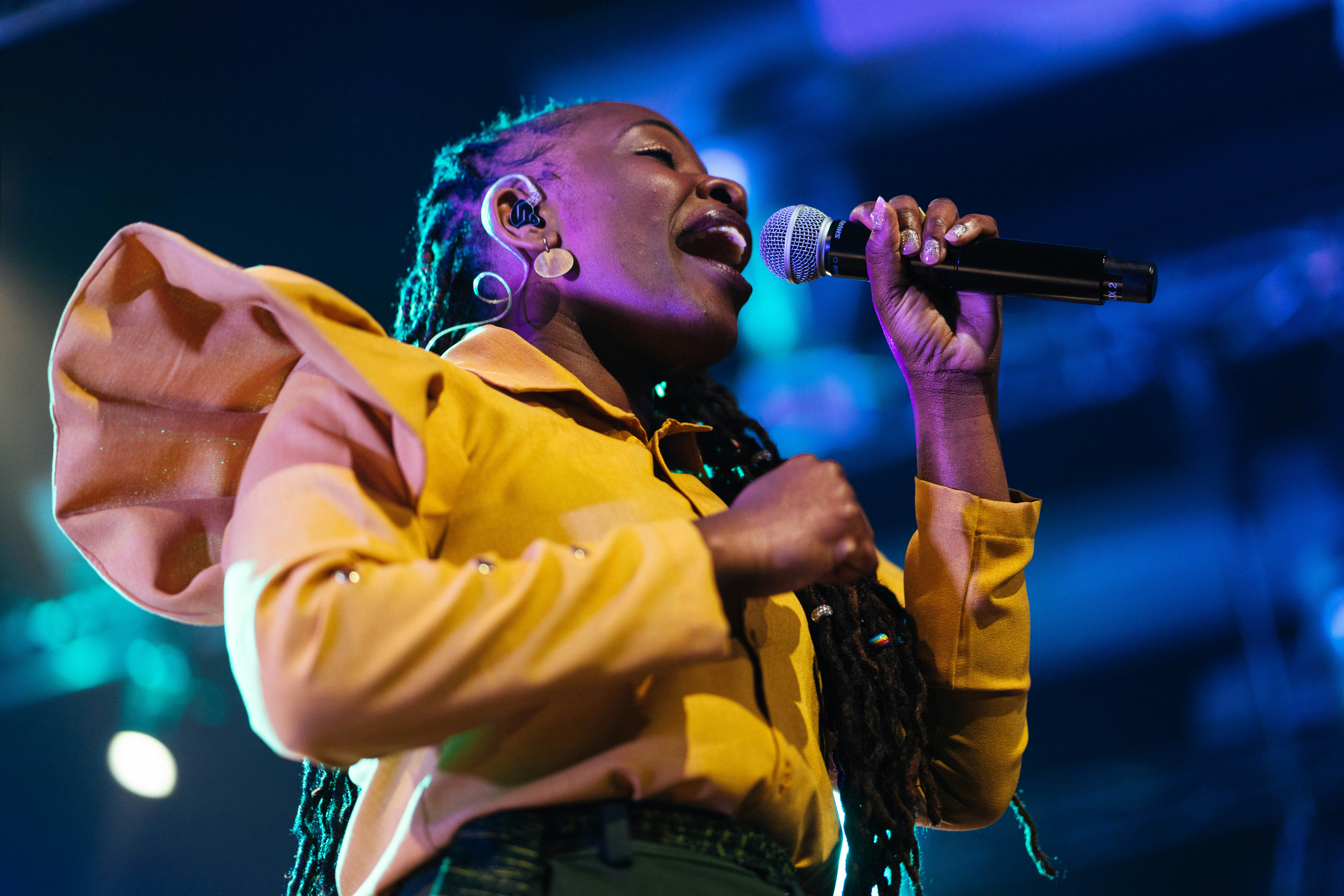 A woman sings powerfully into a microphone.
