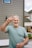 Man gives peace sign, smiling brightly.
