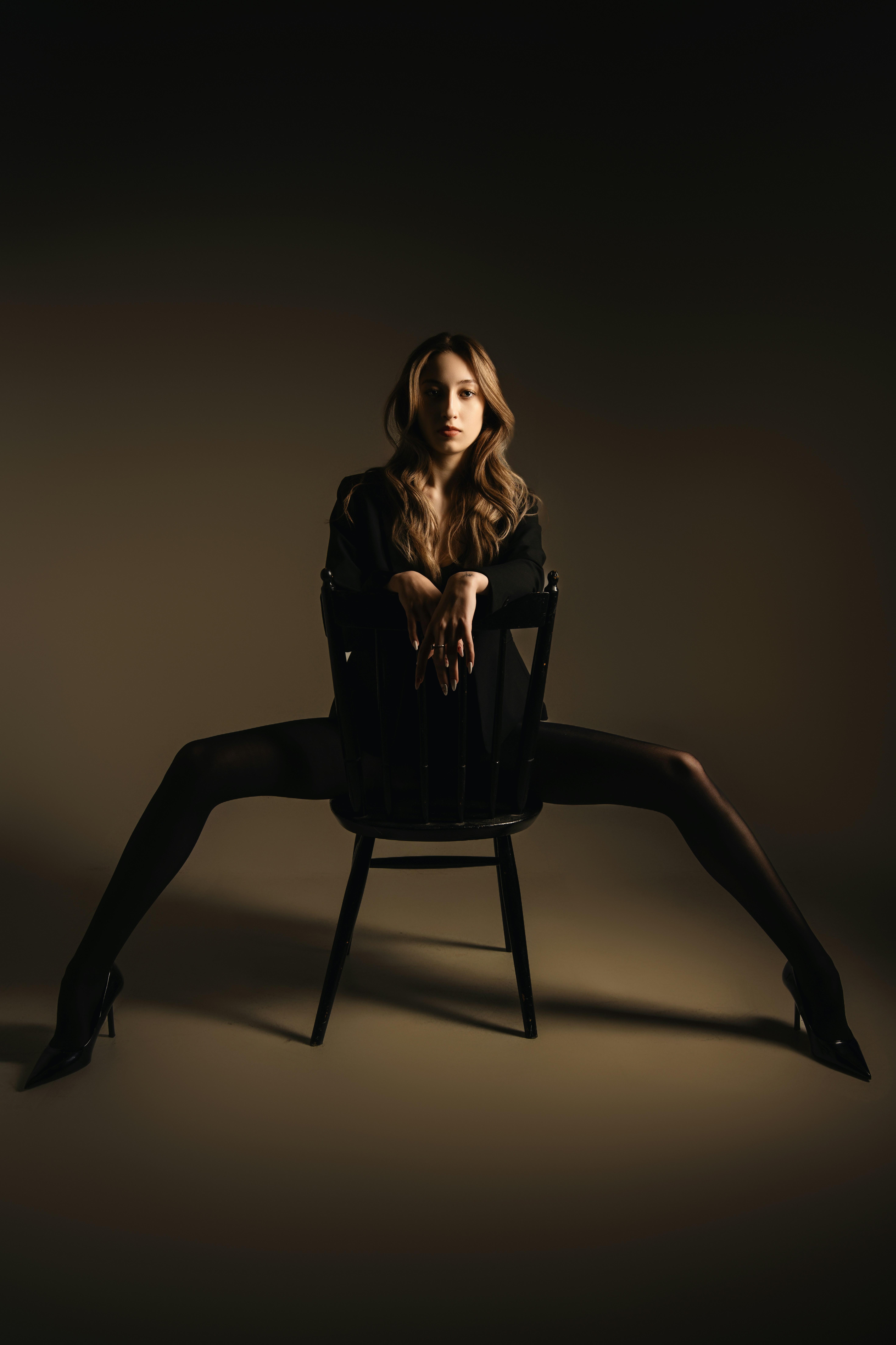 A woman poses on a chair with confidence.