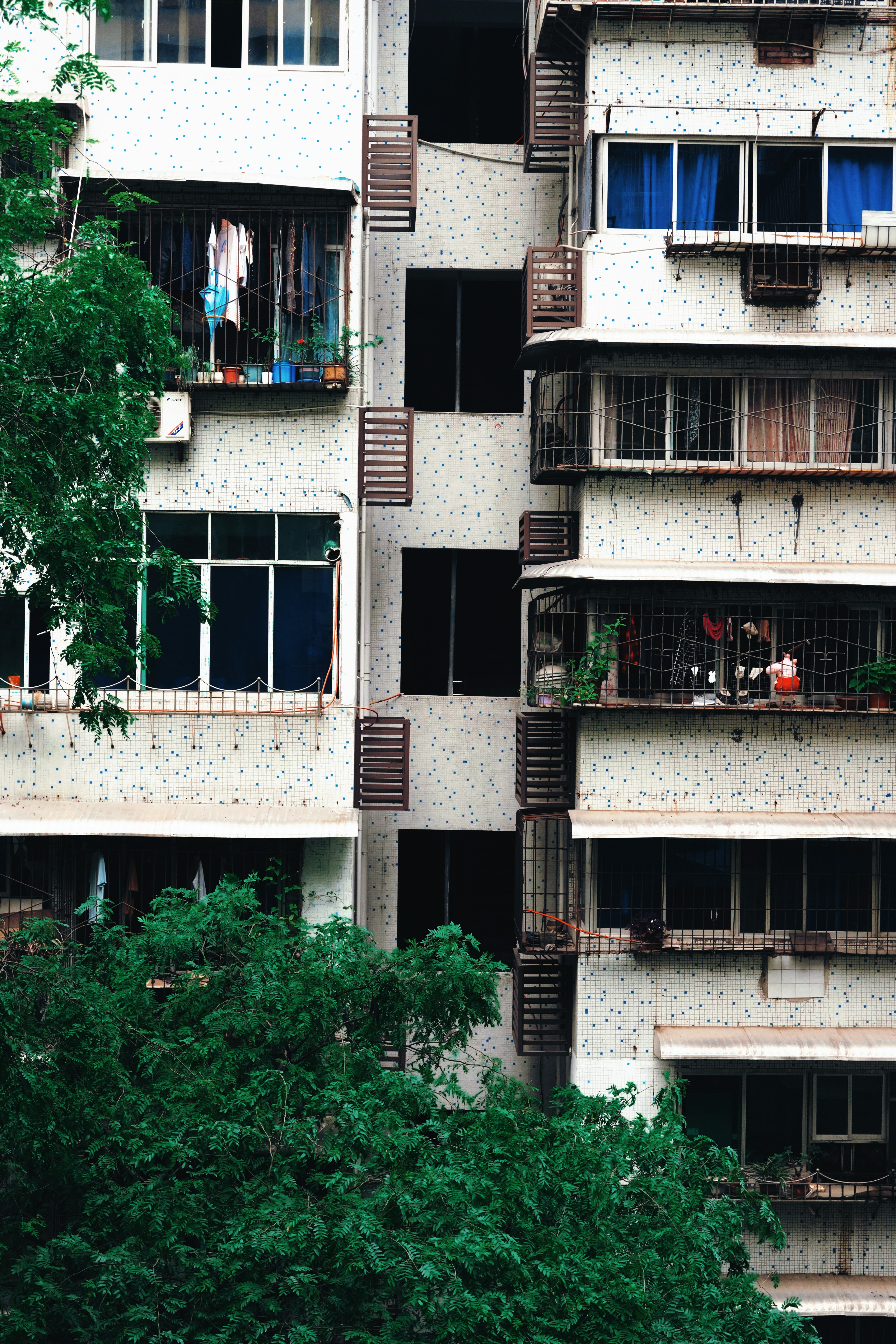 Apartment building with balconies and greenery.