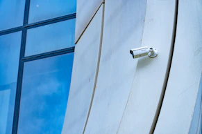 A security camera is mounted on a building wall.