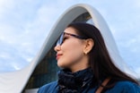 Woman poses by a modern, white architectural marvel.