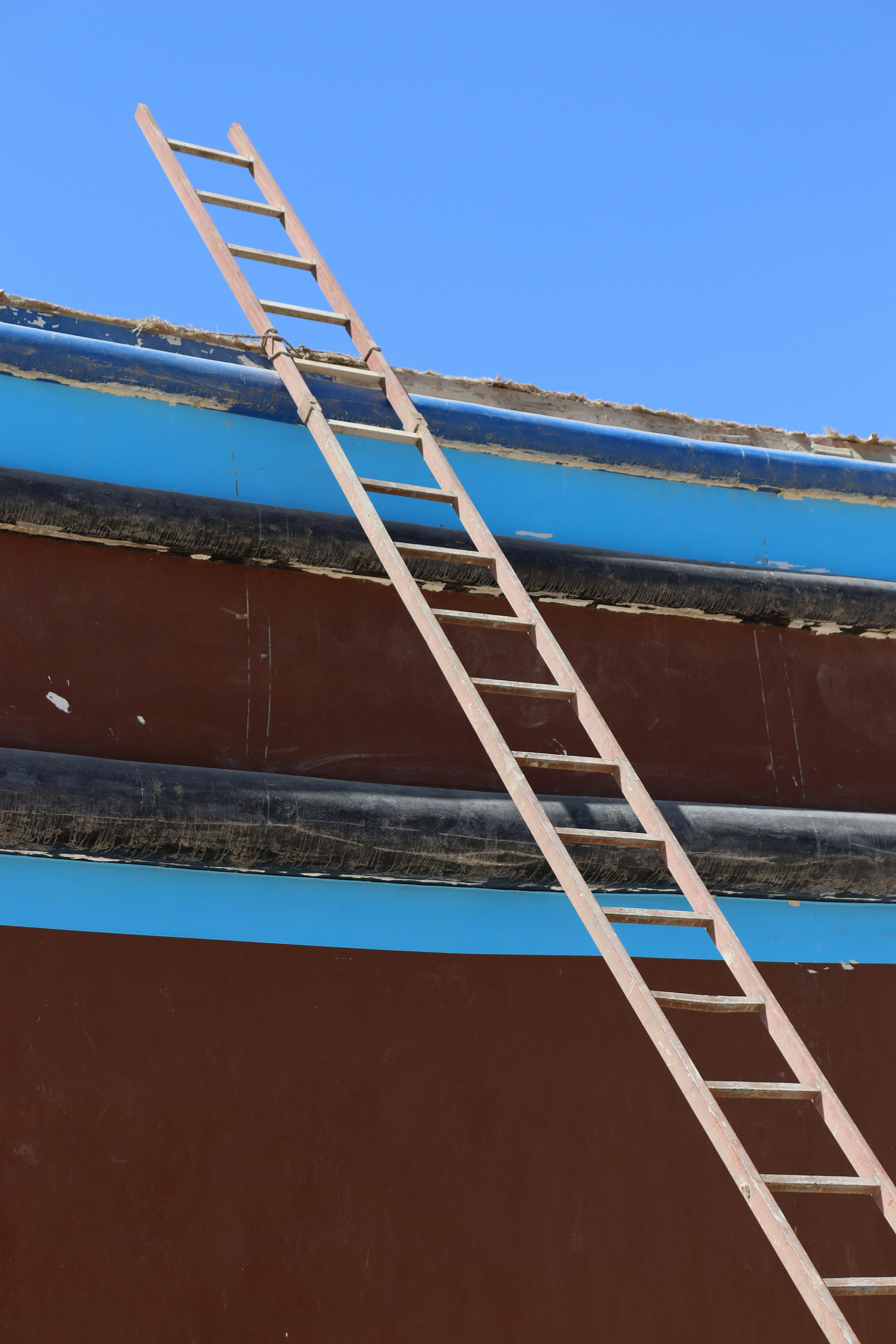 A ladder leans against a boat's hull.