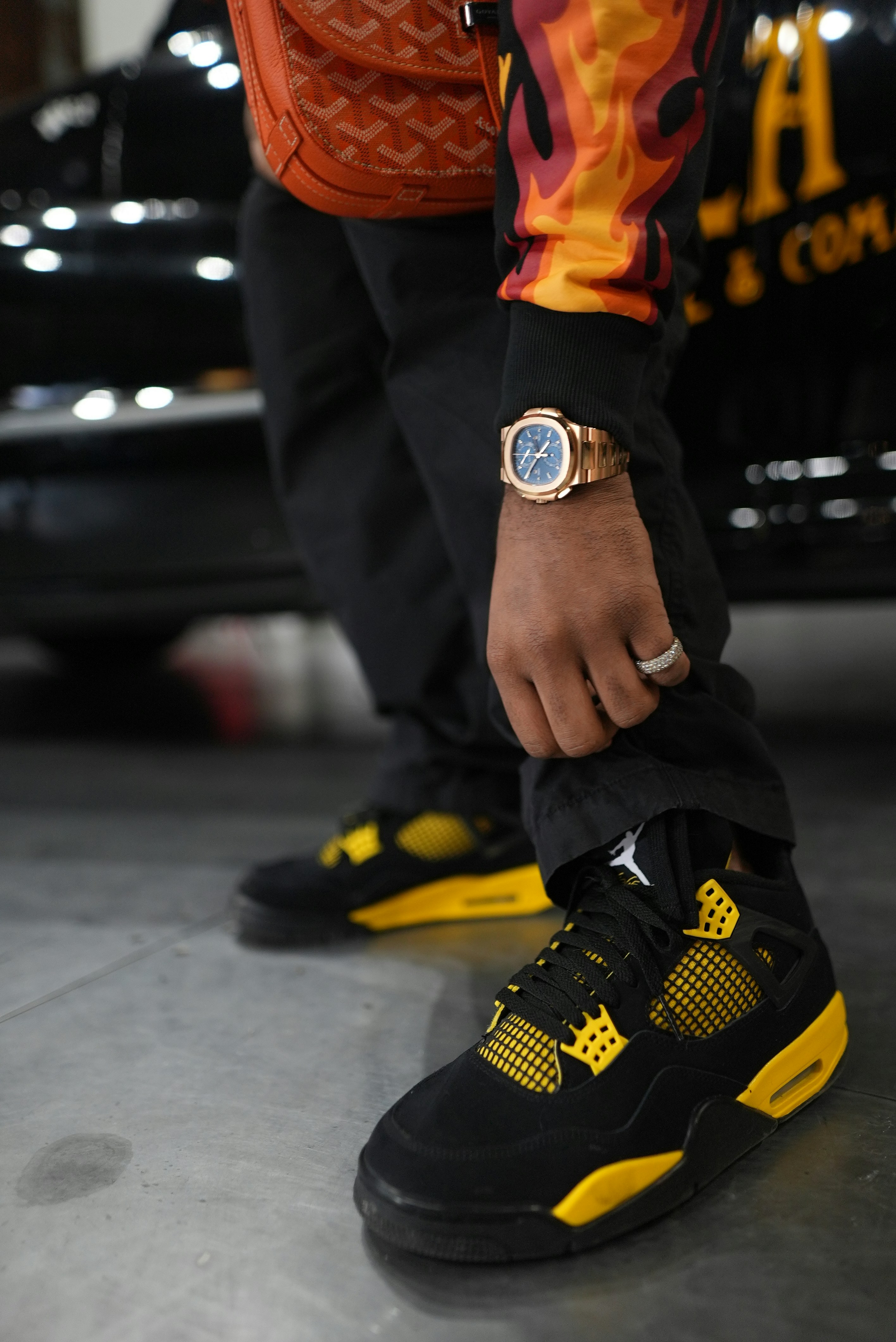 L’homme exhibe sa montre en or et ses baskets élégantes.