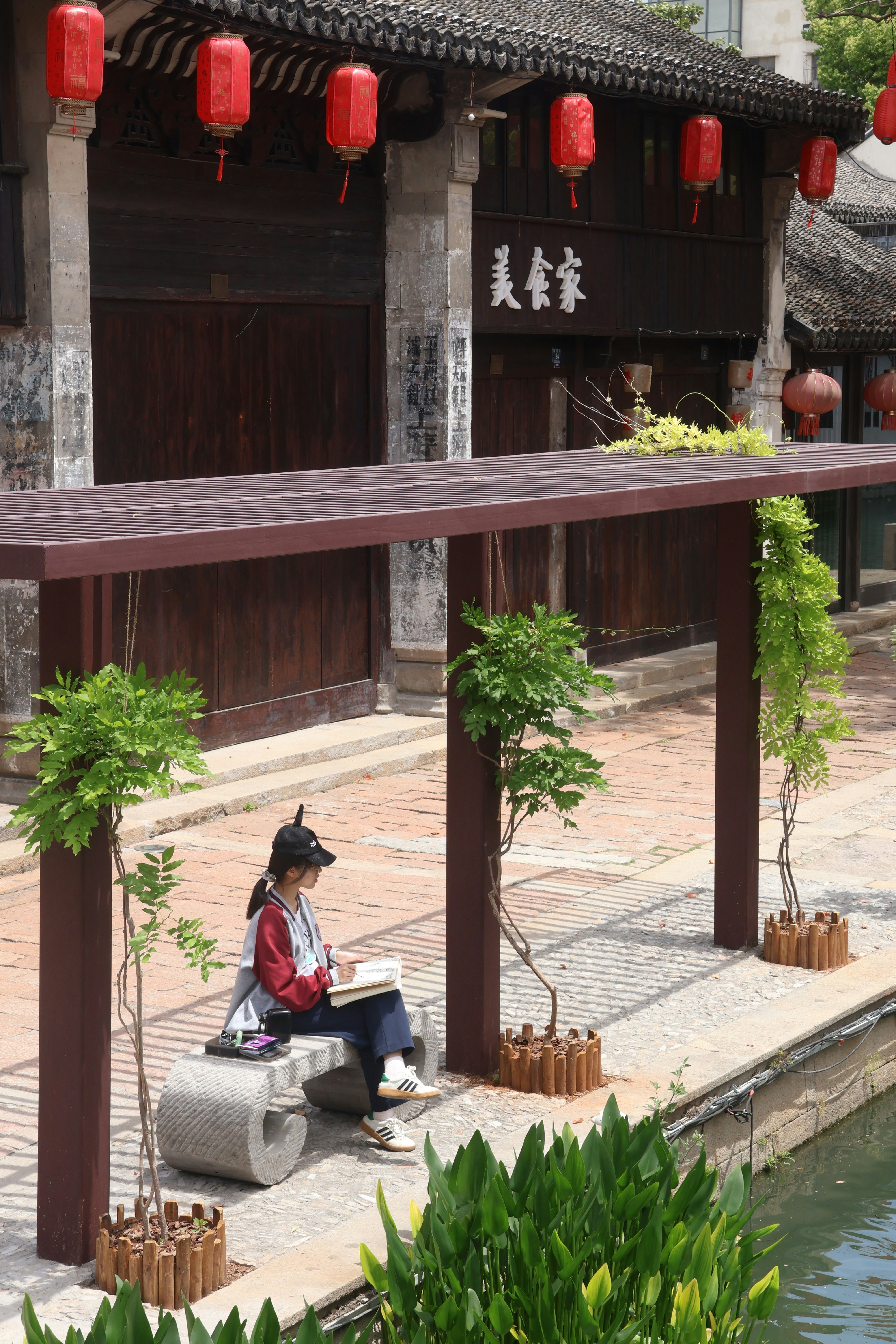 A person studies outside a traditional building.