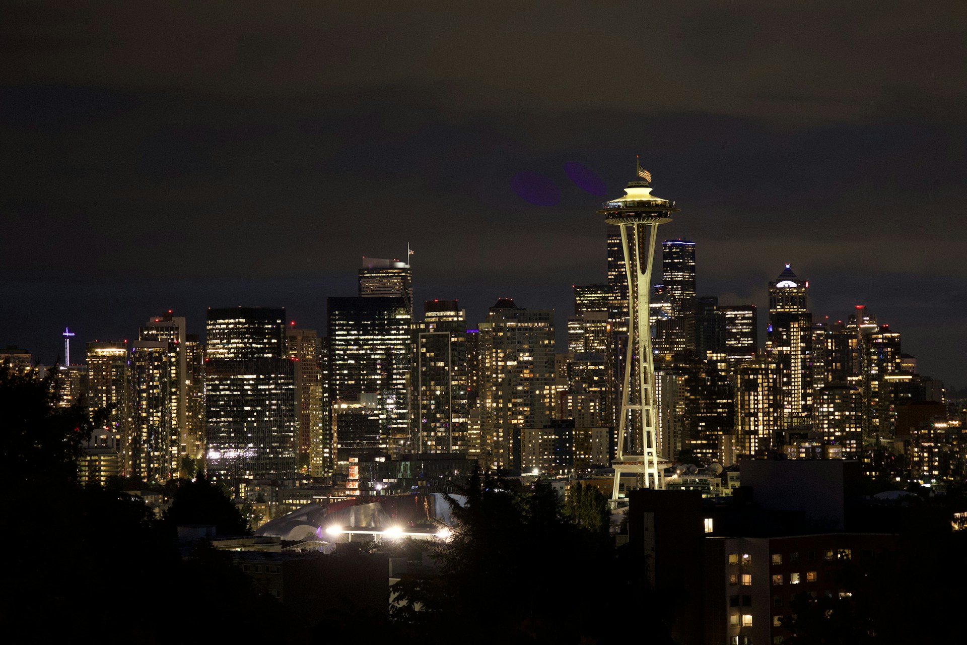 Seattle skyline glows brightly at night.
