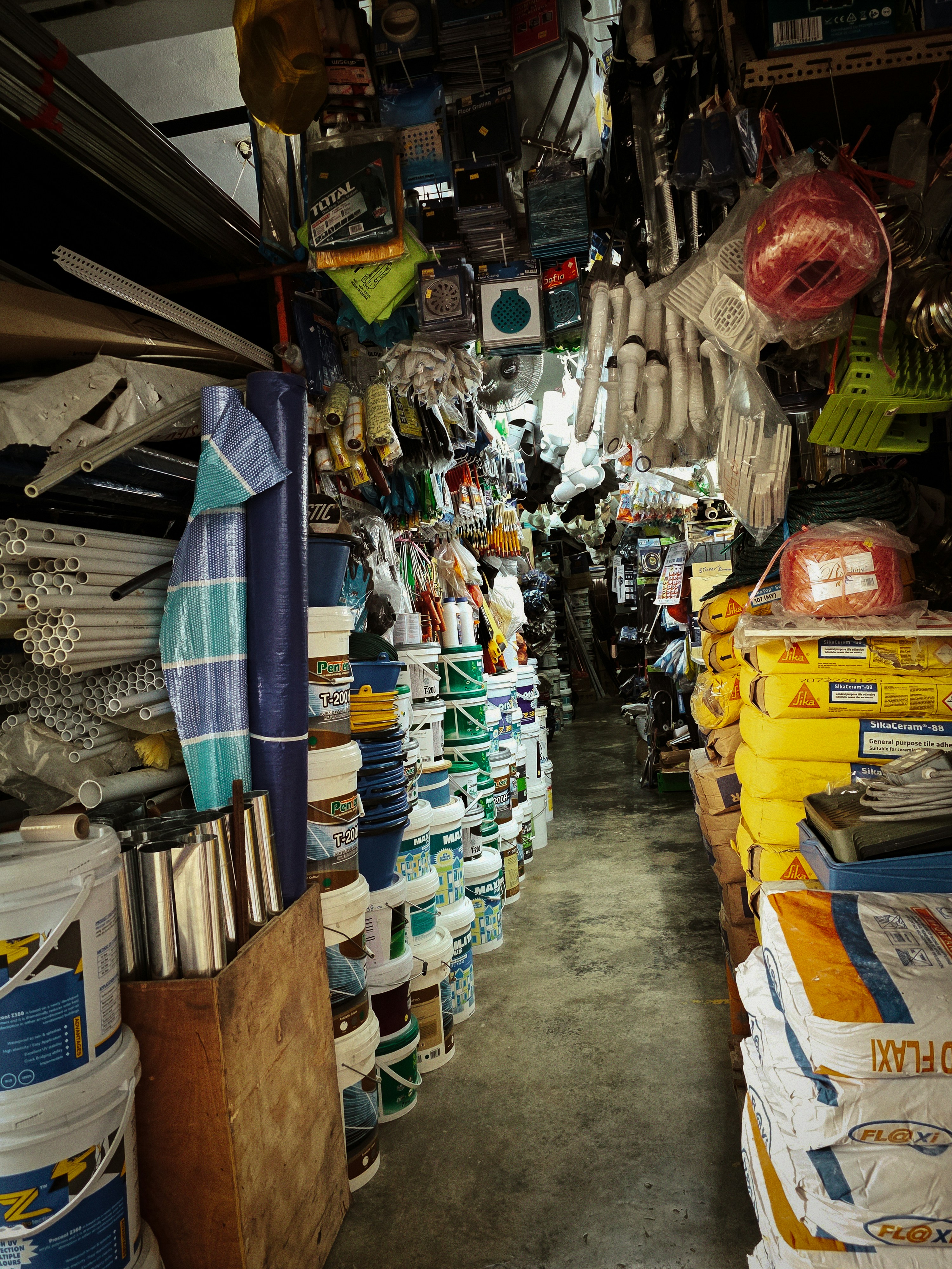 A cluttered hardware store aisle with various items.
