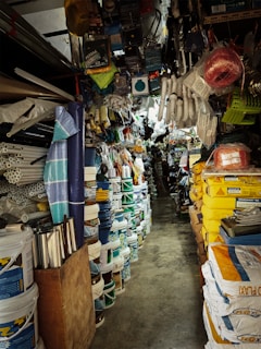 A cluttered hardware store aisle with various items.