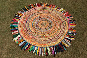 A colorful, circular rug with a fringe.